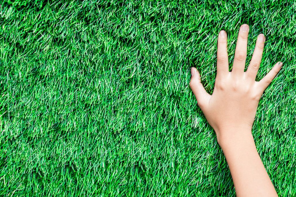Environmental care hand on synthetic grass